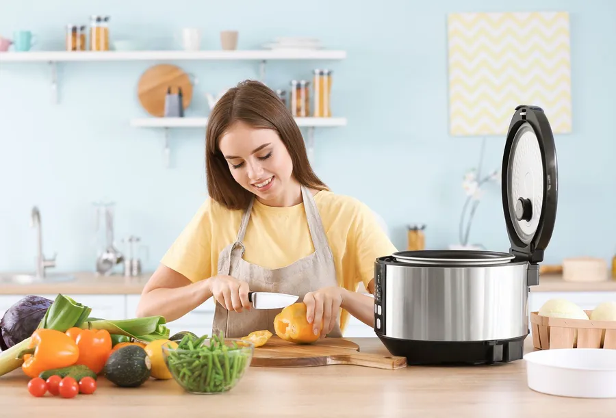 Cuve amovible et panier vapeur d'un multicuiseur posés à côté de l'appareil ouvert